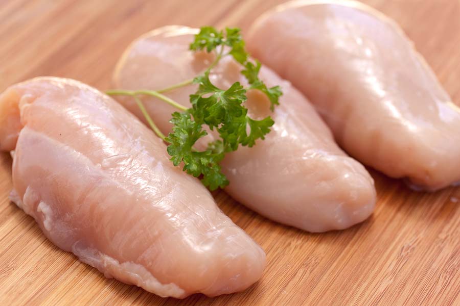 chicken breast fillets on wooden chopping board background. ** Note: Shallow depth of field